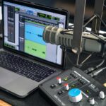 Professional podcast equipment setup featuring a microphone, headphones, audio interface, camera, and lighting for high-quality audio and video recording.